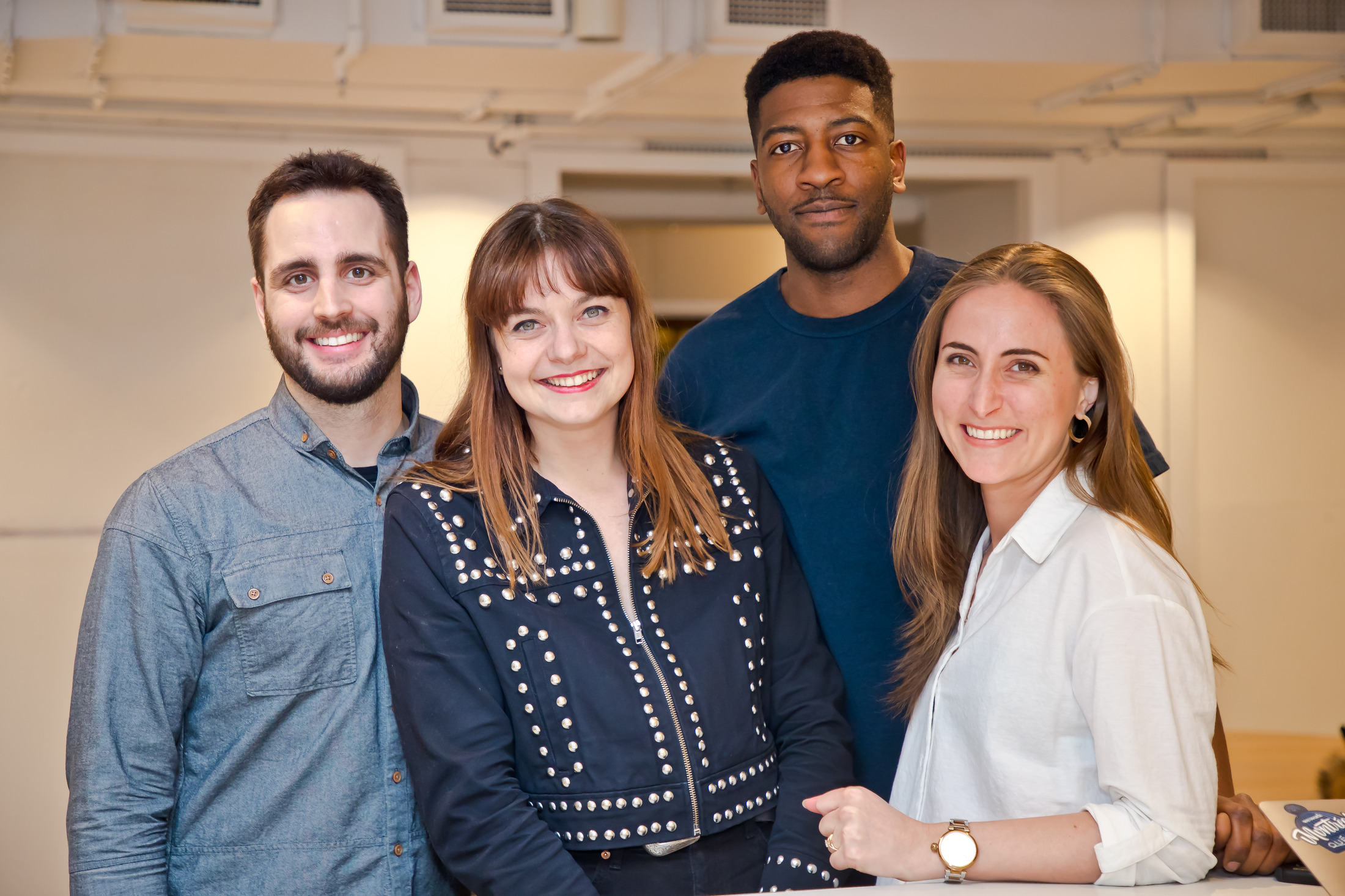 Four friends posing for a group portrait at an event