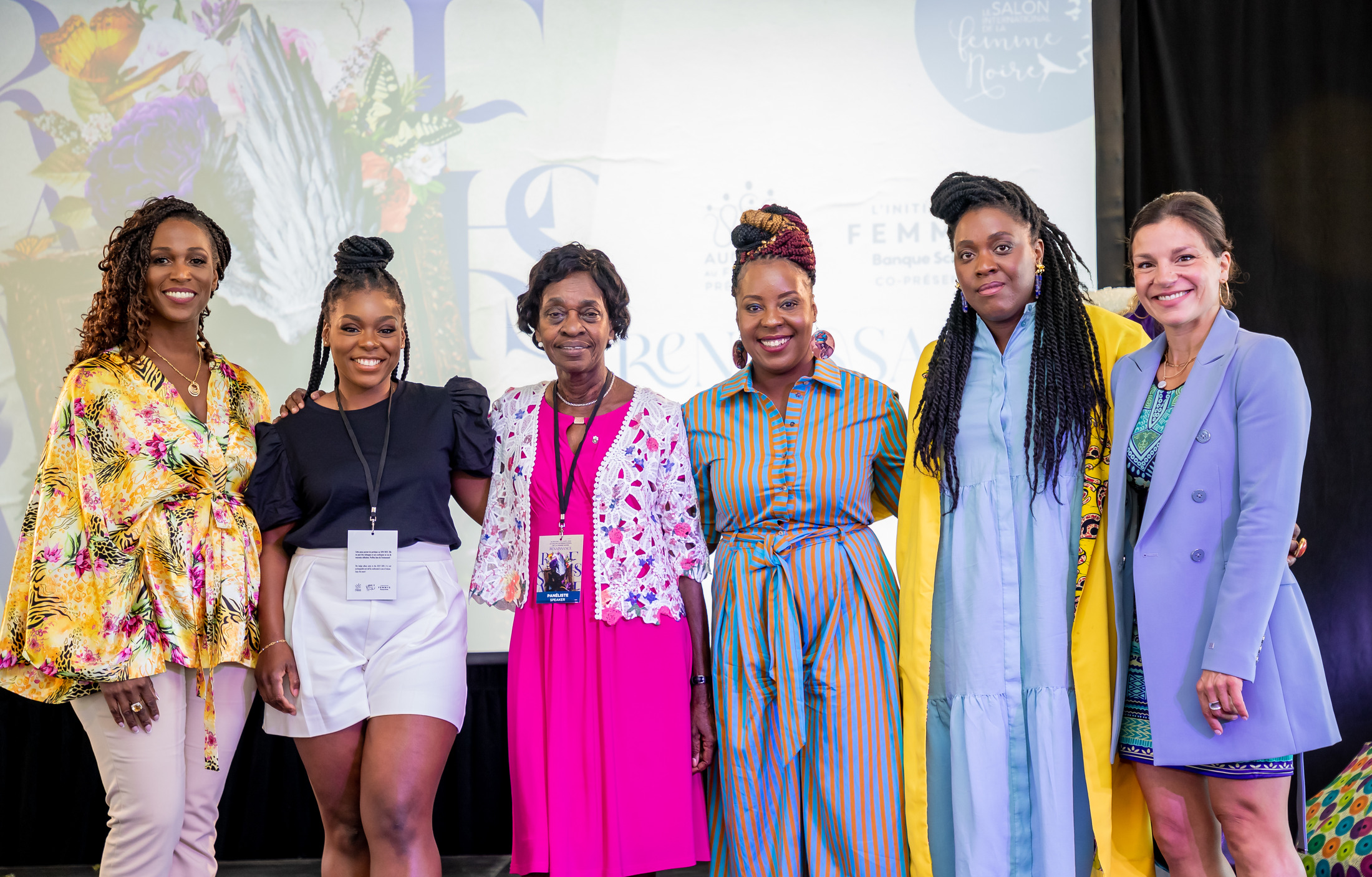 Group portrait of women on stage in front of a floral backdrop