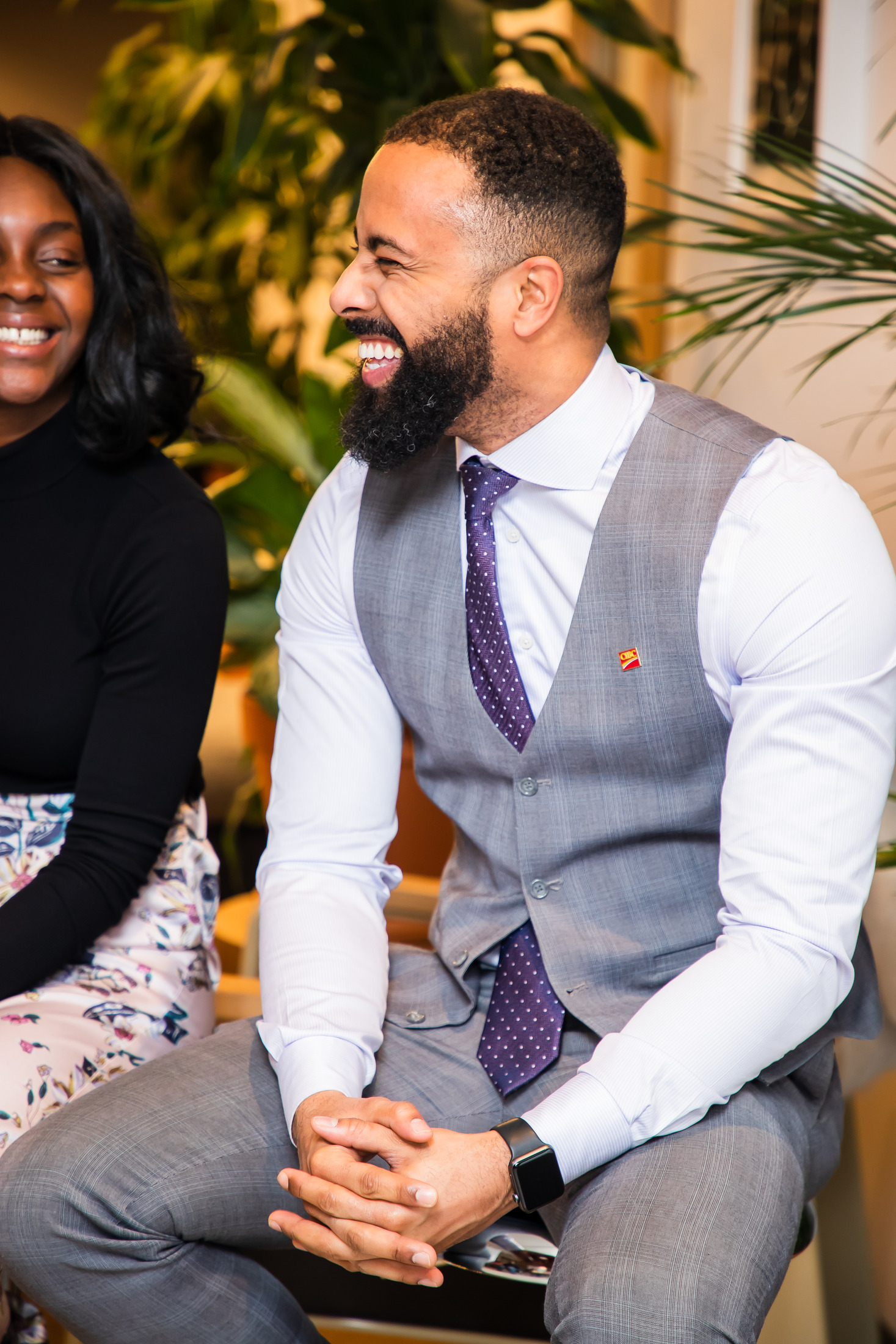 Panel guest in a three-piece suit smiling at an event