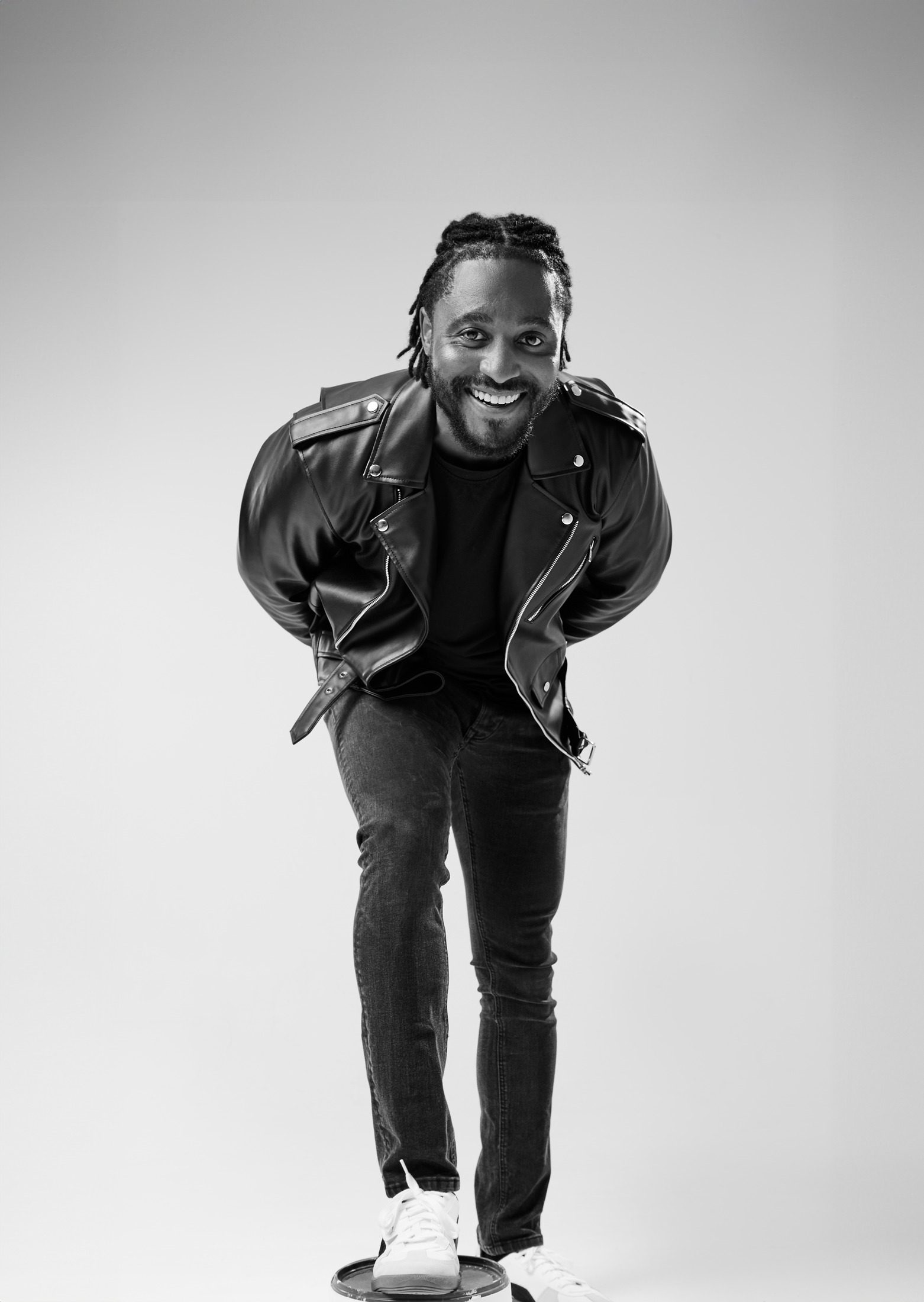 Full-length black and white portrait of a man in a leather jacket